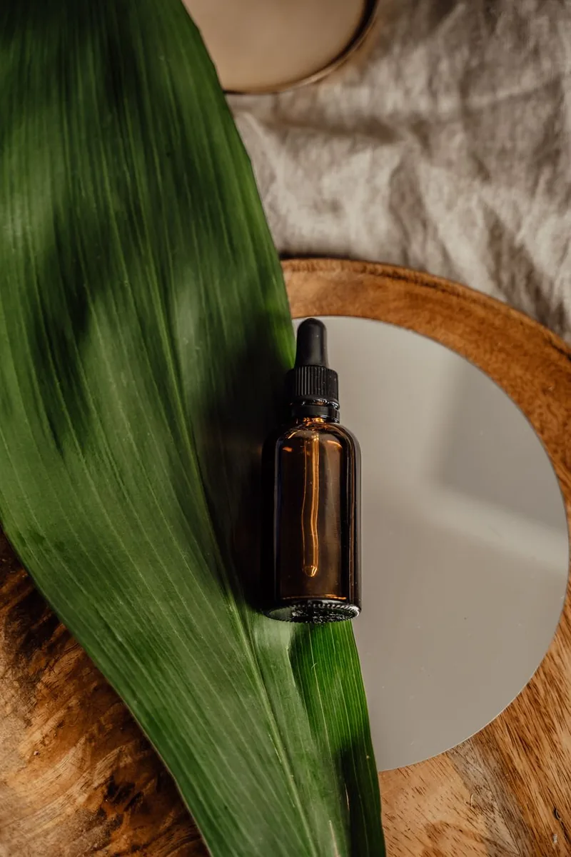 Natural ayurvedic facial oil in an amber dropper bottle on a leaf